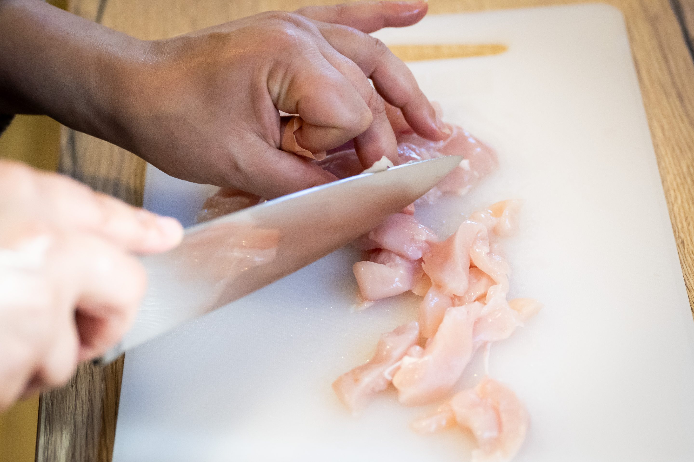CARDIFF, WALES - NOVEMBER 6: In this photo illustration, A woman cuts raw chicken with a knife on a chopping board November 6, 2023 in Cardiff, Wales. (Photo by Matthew Horwood/Getty Images)