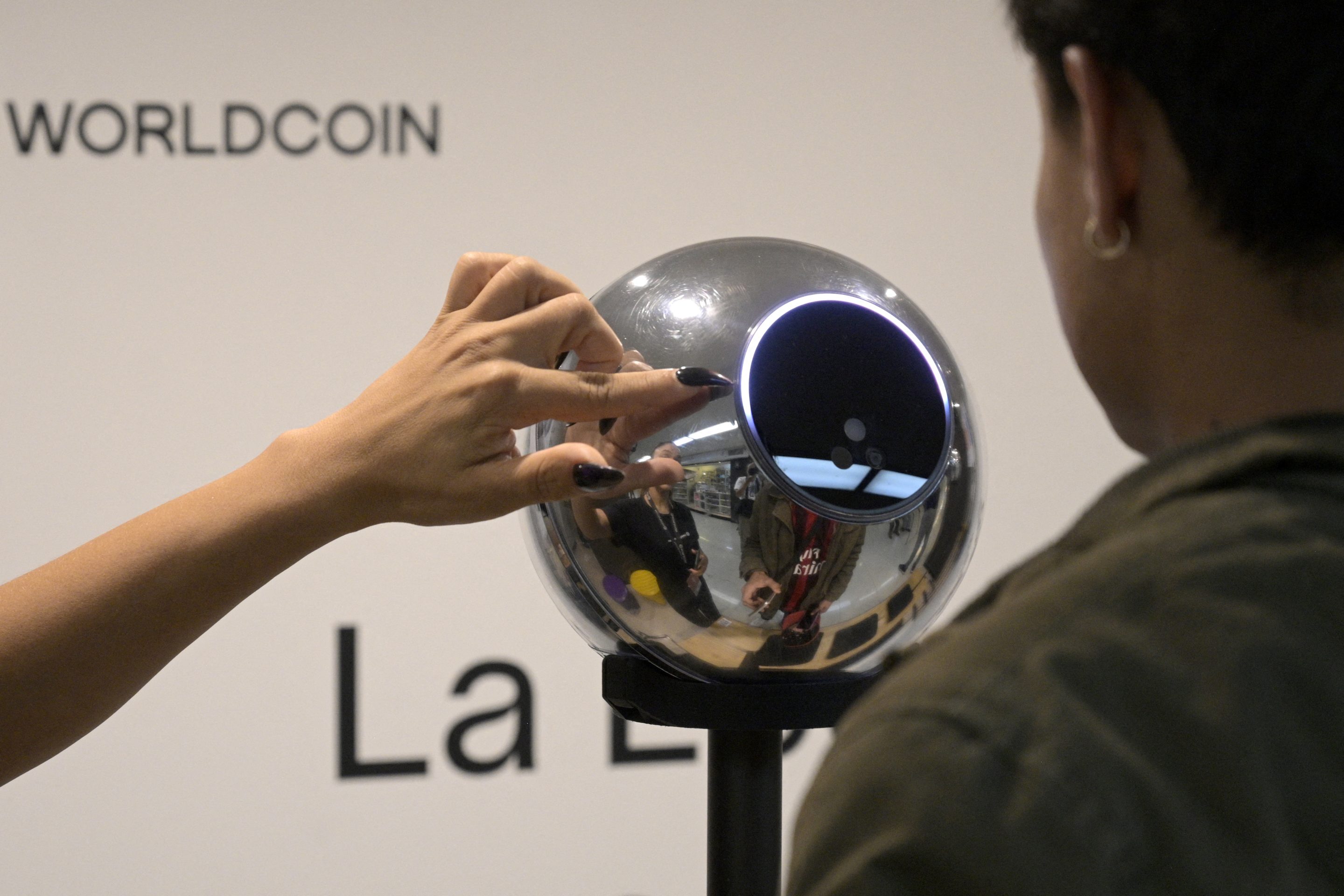 A man has his iris scanned with an orb, a biometric data scanning device, in exchange for the Worldcoin cryptocurrency in Buenos Aires on March 22, 2024. In recent months, hundreds of thousands of Argentines have stood in front of a Worldcoin orb to scan the iris of their eyes in inflation-hit Argentina, where recent tightening delivered the coup de grace. The Worldcoin cryptocurrency, with a verification system based on iris recognition and launched in July 2023 by OpenAI CEO Sam Altman, is being closely watched by regulators in several countries due to data protection concerns. (Photo by JUAN MABROMATA / AFP) (Photo by JUAN MABROMATA/AFP via Getty Images)
